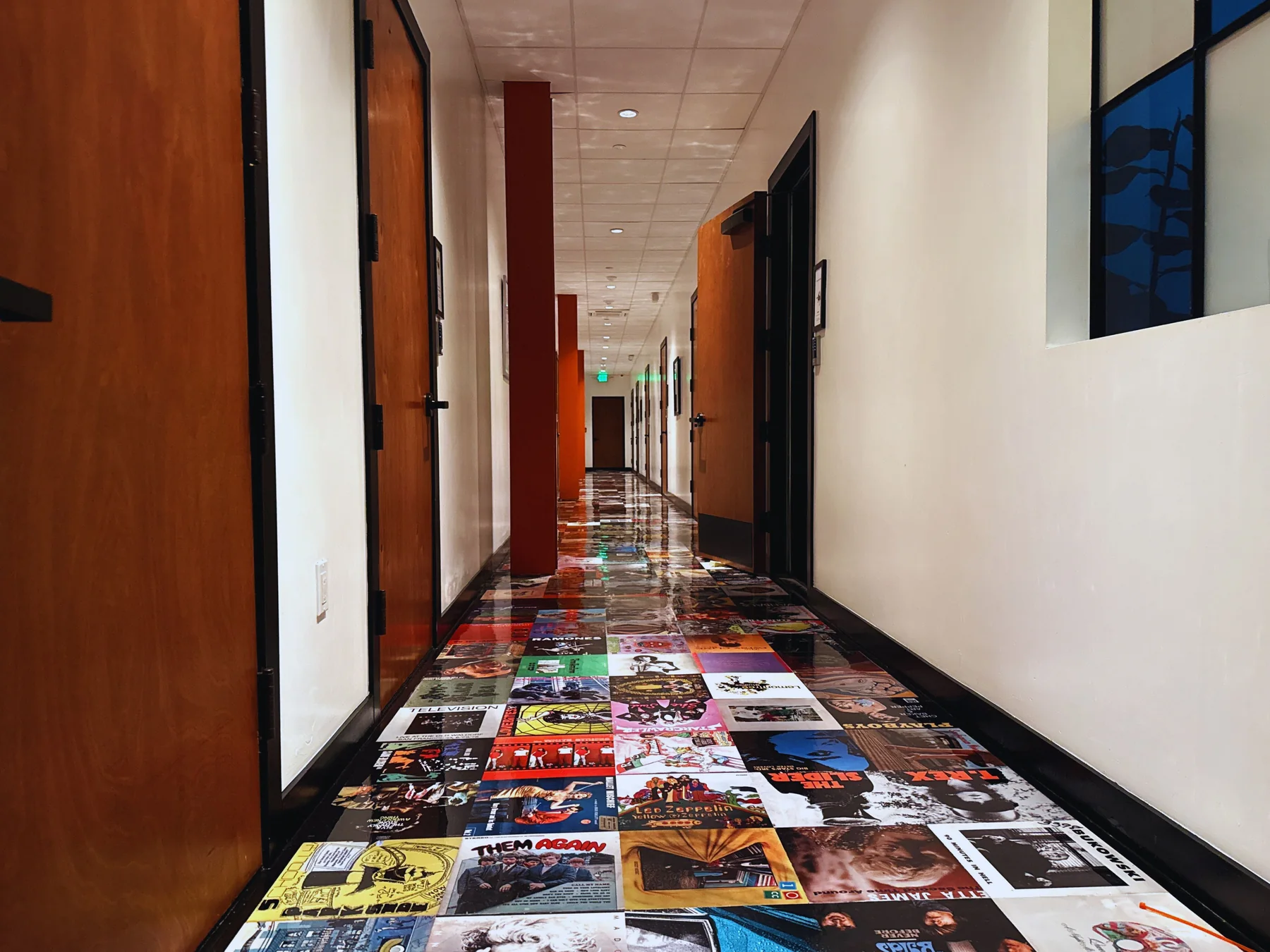 The Highland Park hallway with wood studio doors and record-cover flooring