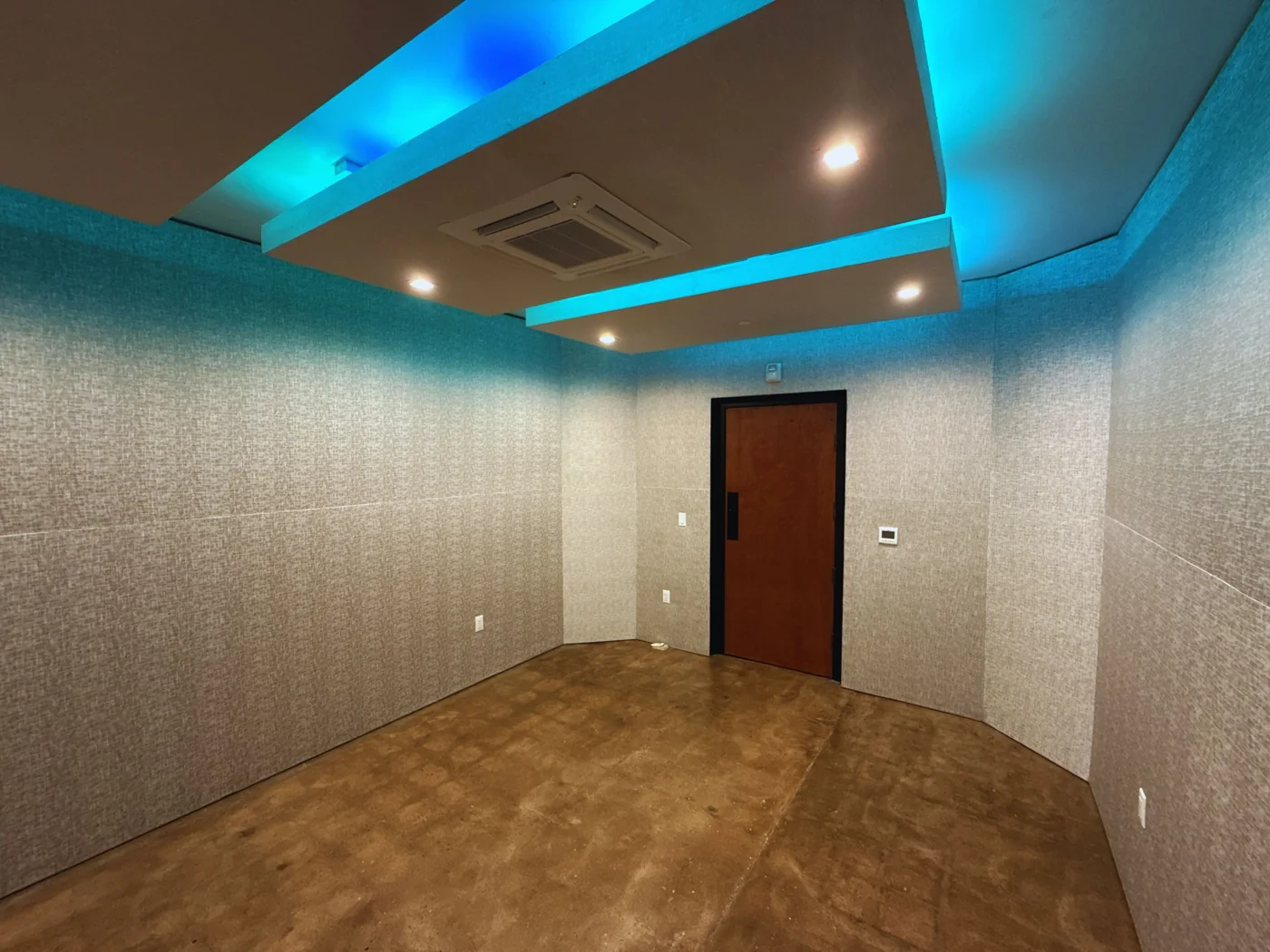 A Highland Park studio control room with blue ceiling lights, fabric acoustic walls and wood floors